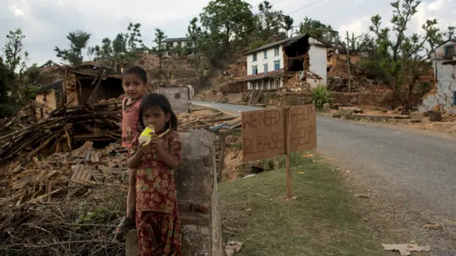 新图巴尔恰克县两名受灾儿童站在求救标语牌旁边(2/5/2015)