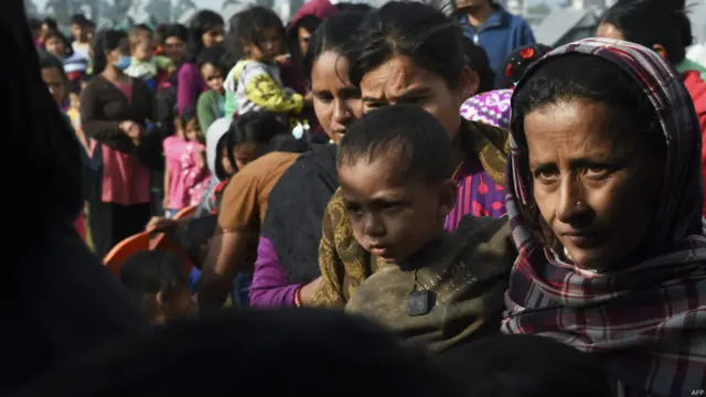 خواتین بچوں کے لیے دیے جانے والے کھانے پینے کا سامان لینے کے لیے قطار میں کھڑی اپنی باری کا انتظار کر رہی ہیں۔