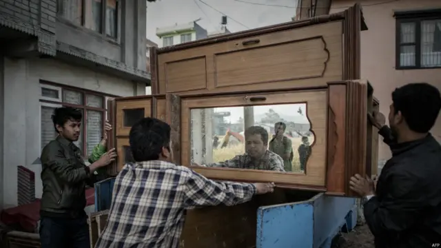 متاثرین زلزلے میں تباہ ہونے والے مکانات میں سے بچ جانے والا گھریلو سامان گاڑیوں پر لاد کر لے جا رہے ہیں۔ 