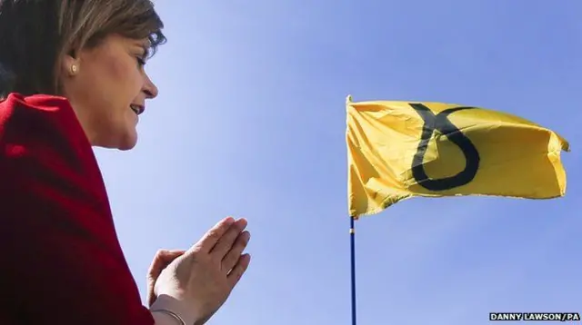 这是苏格兰首席大臣尼古拉·斯特金向支持者表示感谢。可是照片上却显得她好像在对着一面苏格兰民族党的党旗祈祷。