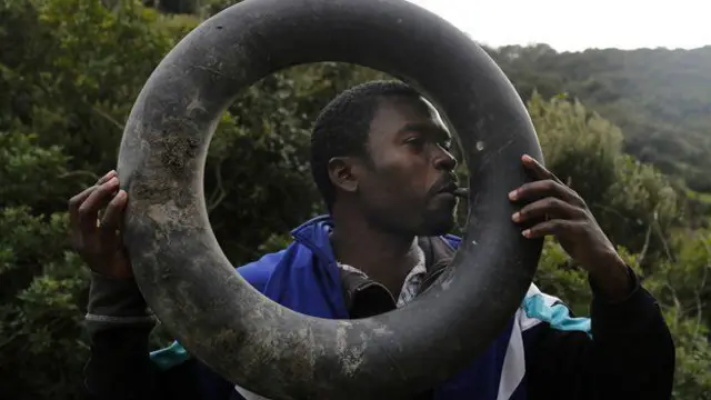 د موټر ټیوب په خولې پوه کول... د سمندر د څپو په وړاندې کډوال هڅه کوي پر داسې یوه څه ځان ونیسي چې د اوبو پر سر یې وساتي. 