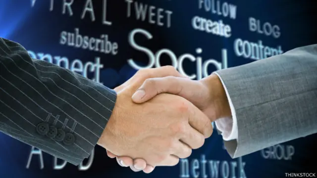 Dos personas que se dan la mano con un fondo de palabras asociadas a las redes sociales