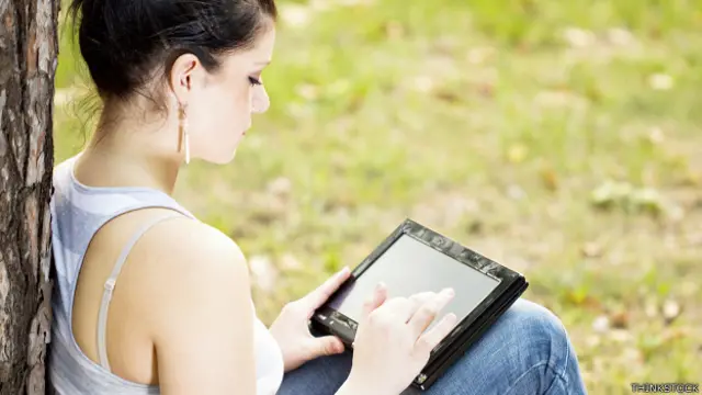 Una joven escribiendo en una tableta
