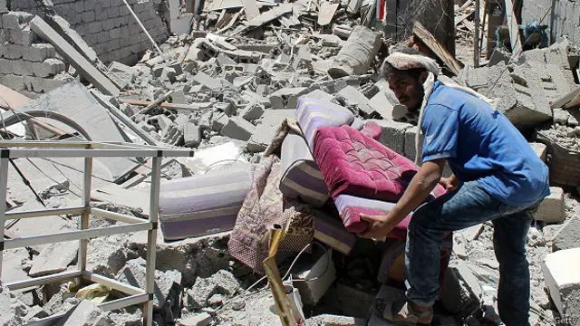 Житель Йемена на развалинах дома