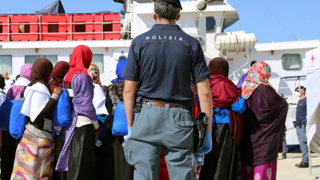 意大利西西里岛奥古斯塔港一名警员监视偷渡者下船(9/5/2015)