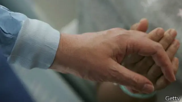 Un familiar muestra su apoyo agarrando de la mano a un trasplantado