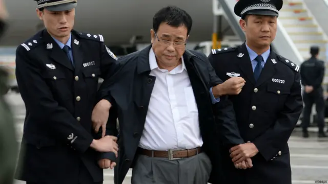 李华波(中)在北京首都机场被押下飞机(新华社图片9/5/2015)