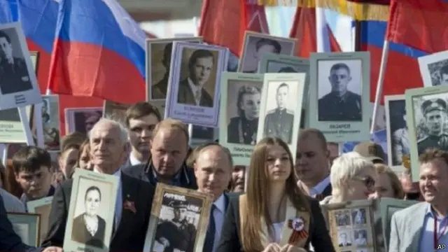 الرئيس بوتين انضم لمسيرة في الساحة الحمراء بموسكو وهو يحمل صورة لوالده بالزي العسكري