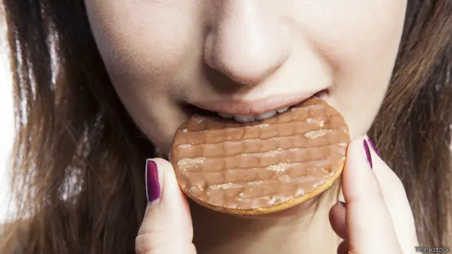 Девушка надкусывает печенье