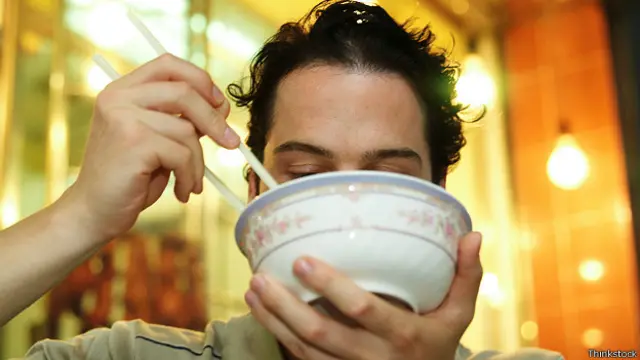 Мужчина ест лапшу из тарелки