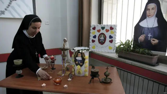 耶路撒冷一家女子高中內一名羅馬天主教修女在整理瑪利亞·阿方西娜·加塔斯修女的祭壇（12/5/2015）