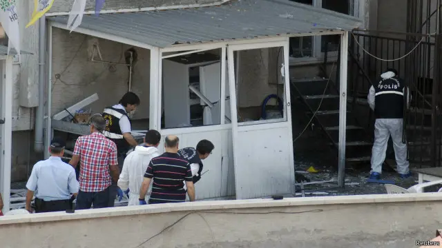 محققون يتتبعون آثار التفجير الذي أصاب مقر حزب الشعب الديمقراطي الموالي للأكراد في مرسين.