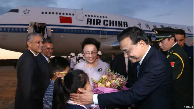 图为少年向李克强和夫人程虹献上鲜花)。