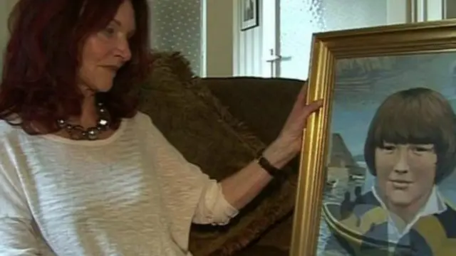 爱尔兰共和军爆炸案受害者母亲手持罹难儿子的画像 