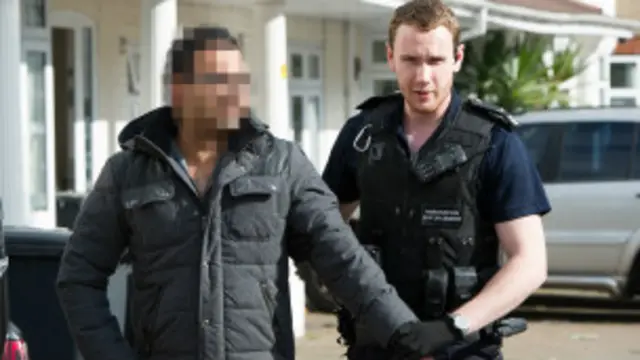 Polisi wa Uingereza akimdhibiti mhamiaji haramu