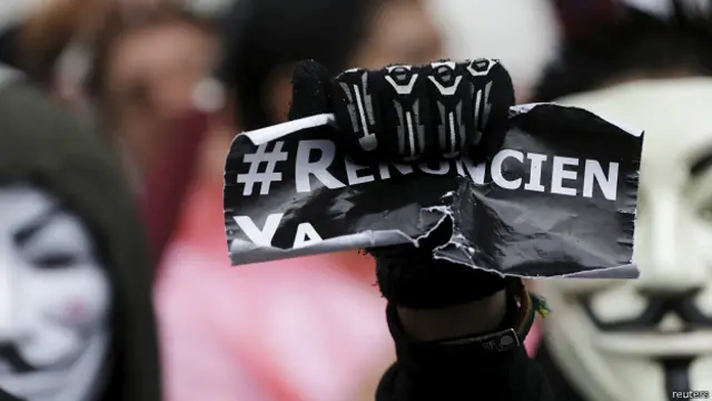 Un manifestante en Guatemala muestra el hashtag #RenunciaYa