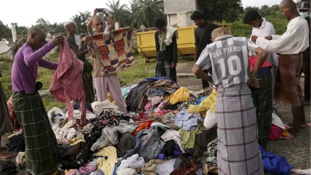Sebagian pengungsi Rohingya dan Bangladesh tengah memeriksa pakaian hasil sumbangan warga Indonesia.