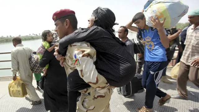 جندي عراقي يحمل سيدة مسنة عابرا بها جسر بزيبز الذي يربط الرمادي بالعاصمة بغداد.
