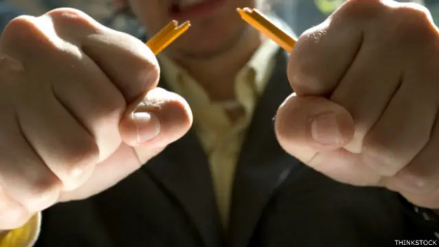 Una persona rompe un lápiz