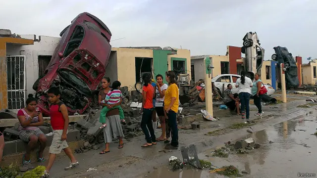 Akibat tornado, ratusan rumah rusak dan sejumlah mobil terangkat ke atap bangunan. 