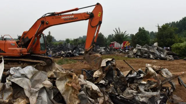 鲁山老年公寓火灾现场一台挖土机在清理房舍残骸(新华社图片26/5/2015)