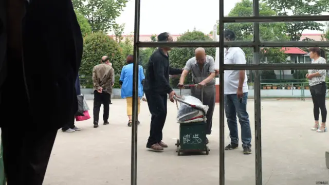 鲁山老年公寓火灾现场一台挖土机在清理房舍残骸(新华社图片26/5/2015)