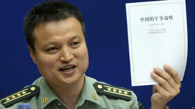 楊宇軍大校在北京的發佈會上舉起《中國的軍事戰略》白皮書(26/5/2015)