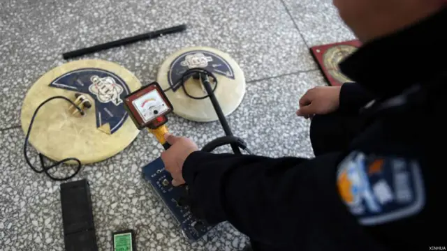 警員展示盜墓者使用的金屬探測儀(新華社圖片10/4/2015)