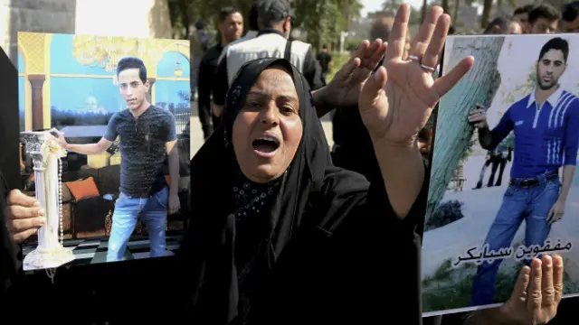 इराक़ी माँ अपने लापता बच्चे की तस्वीर के साथ.