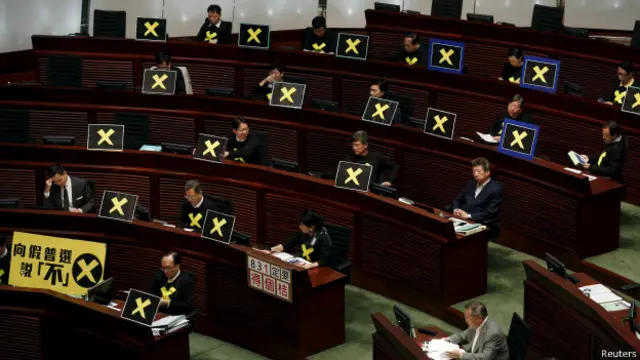 香港泛民主派议员在立法会议事厅内展示抗议政改方案标语牌（22/4/2015）