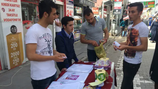 HDP gönüllüleri, Ağrı’nın Cumhuriyet Caddesi’nde seçmenlere, oylarının geçersiz sayılmaması için pusulayı nasıl katlamaları gerektiğini gösteriyor.
