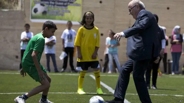 Blatter, presidente de la FIFA juega con niños