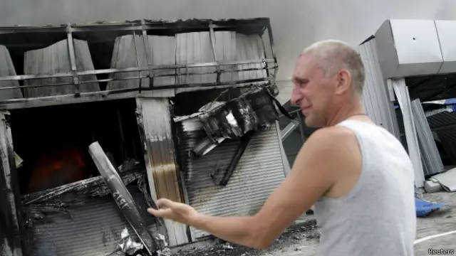 Мужчина возле разрушенного магазина в Донецке