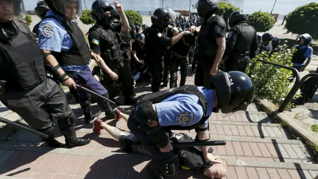 Милиционер задерживает нападавшего