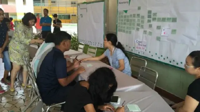 معزون يتركون رسائل تعاطف ومواساة في مدرسة في سنغافورة تأكد مقتل عدد من تلاميذها في زلزال ماليزيا