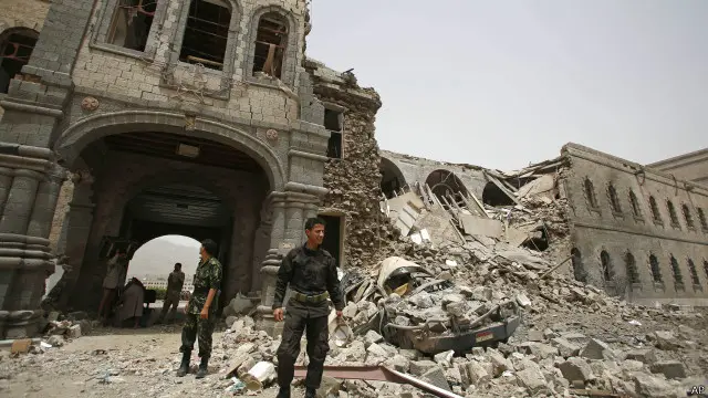 جنود حوثيون يتفقدون منبى وزارة الدفاع اليمنية الذي استهدفته الأربعاء غارة جوية من جانب التحالف العسكري بقيادة السعودية.