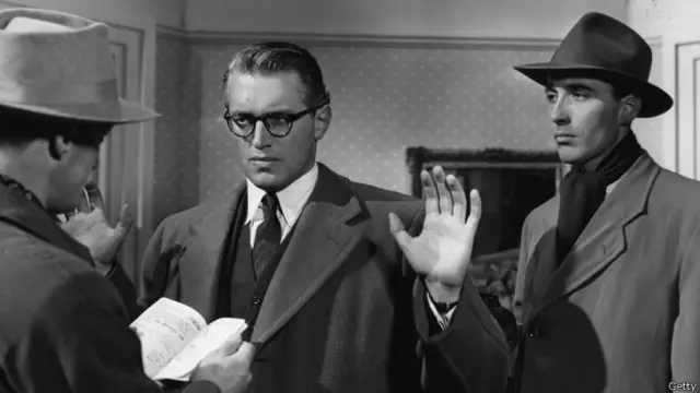 John McCallum levanta sus manos al ser detenido por el policía interpretado por Christopher Lee en "Valle de águilas", dirigida por Terence Young en 1951. Pero este no es el papel más conocido de Lee...