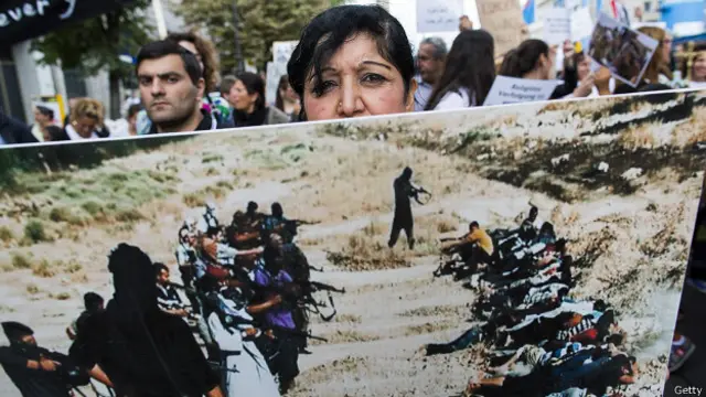 Женщина с плакатом жертв ИГ