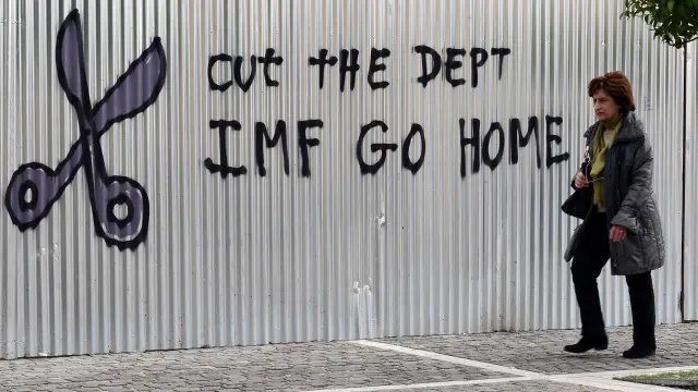 Một khẩu hiệu viết tay của người Hy Lạp nói 'Hãy cắt bỏ nợ, Quỹ tiền tệ quốc tế (IMF) hãy về nước'.