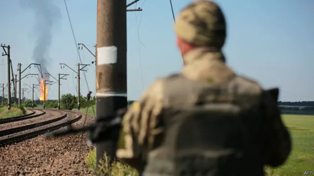 Украинский солдат на фоне горящего газопровода, пострадавшего в результате обстрела