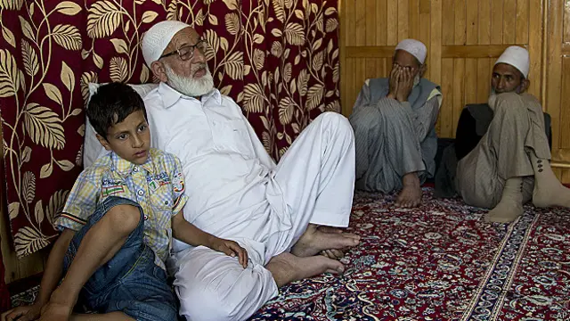 Athar Altaf, son of Sheikh Altafur Rehman who was killed by unknown gunmen, sits with his grandfather Sheikh Mohammed Yousuf