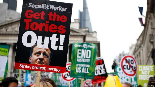 这条标语写着：社会主义工人，让保守党下台，罢工、抗议、占领！ 