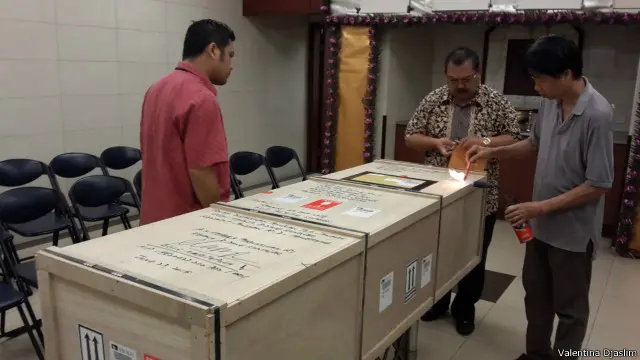 Dua staf KJRI Hong Kong menyaksikan penyegelan peti kargo berisi peti jenazah Wiji Astutik Supardi untuk dikirim pulang.