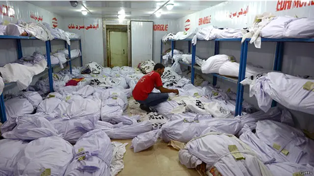 یکی از داوطلبان امدادرسانی در حین وارسی کارت‌های شناسایی کشته‌شدگان در سردخانه ای در کراچی 