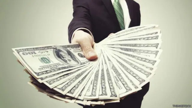 Una persona con un fajo de billetes en la mano