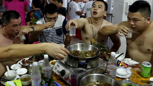 Hombres comiendo carne de perro