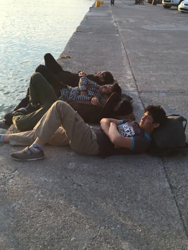 جوانان افغان در جزیره لسبوس پس از ۳۰ ساعت پیادهروی از محلی که کشتی حامل آنها به خشکی رسیده بود، استراحت میکنند