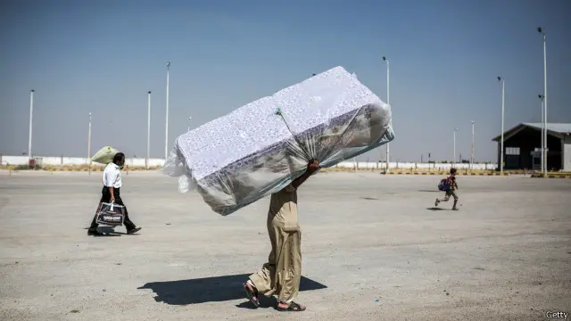 لاجئ سوري في طريق العودة من تركيا، حاملا ما استطاع حمله، إلى تل أبيض بعد طرد المقاتلين الأكراد مسلحي تنظيم "الدولة الإسلامية" من البلدة.