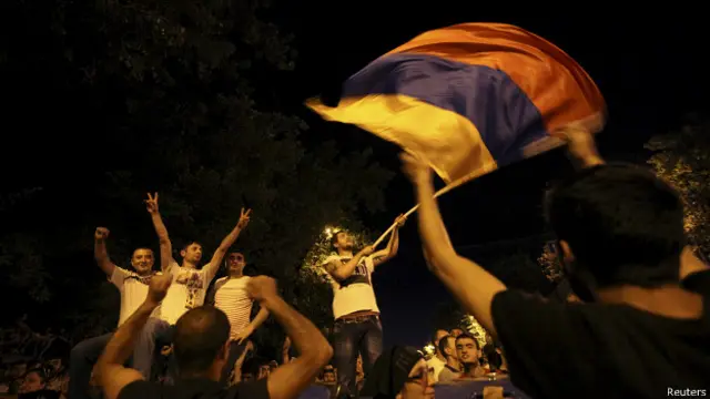 Демонстранты размахивают флагом на баррикадах