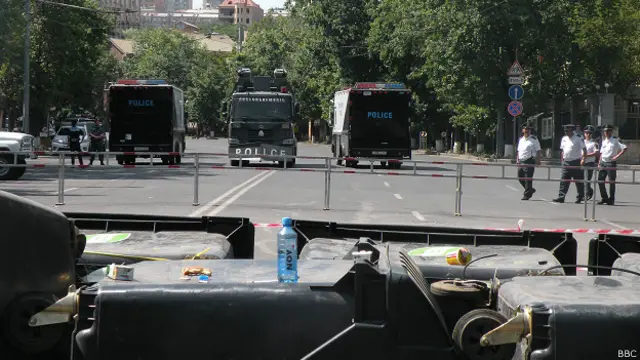 Протестующие сидят перед линией оцепления полиции